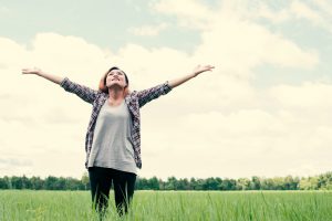 Freedom Young beautiful woman stretching her arms into the sky enjoy and happy with fresh air at grassland.